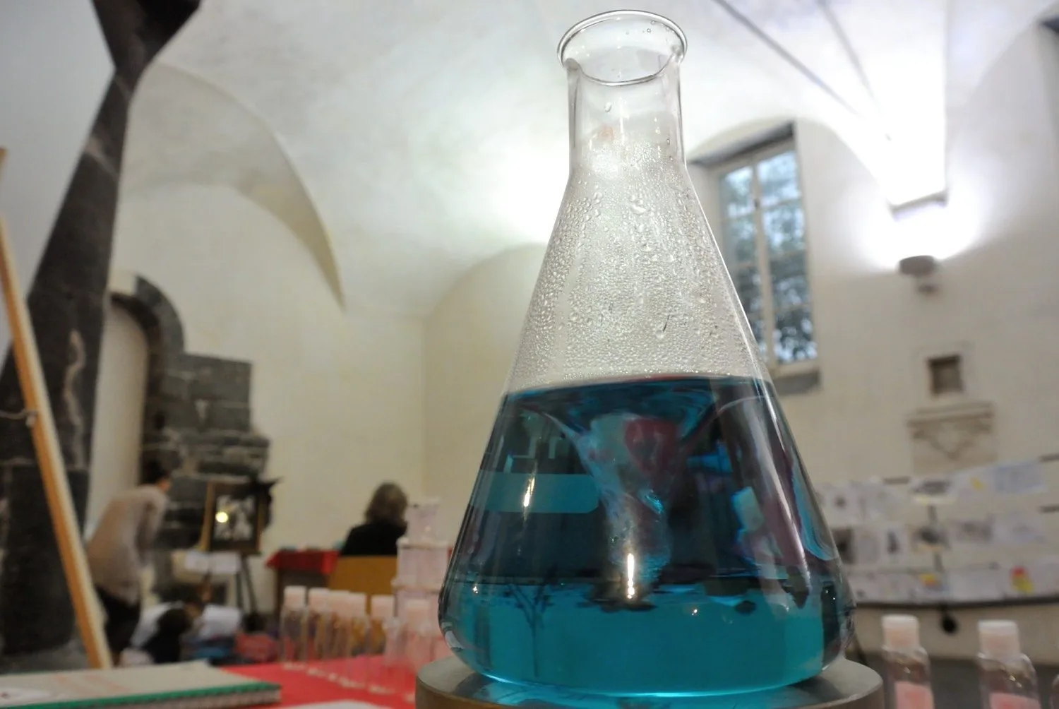Una beuta con liquido azzurro su un banco di laboratorio durante il Festival della Scienza di Genova