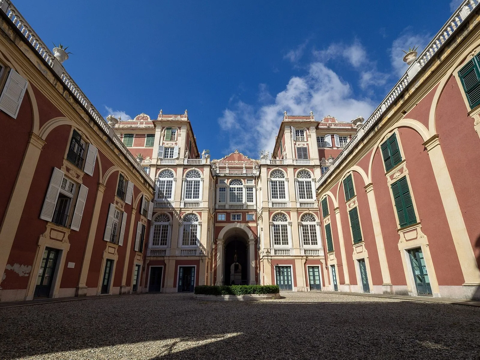 Il cortile di Palazzo Reale in via Balbi a Genova, con le facciate rosse e gialle sotto il cielo azzurro